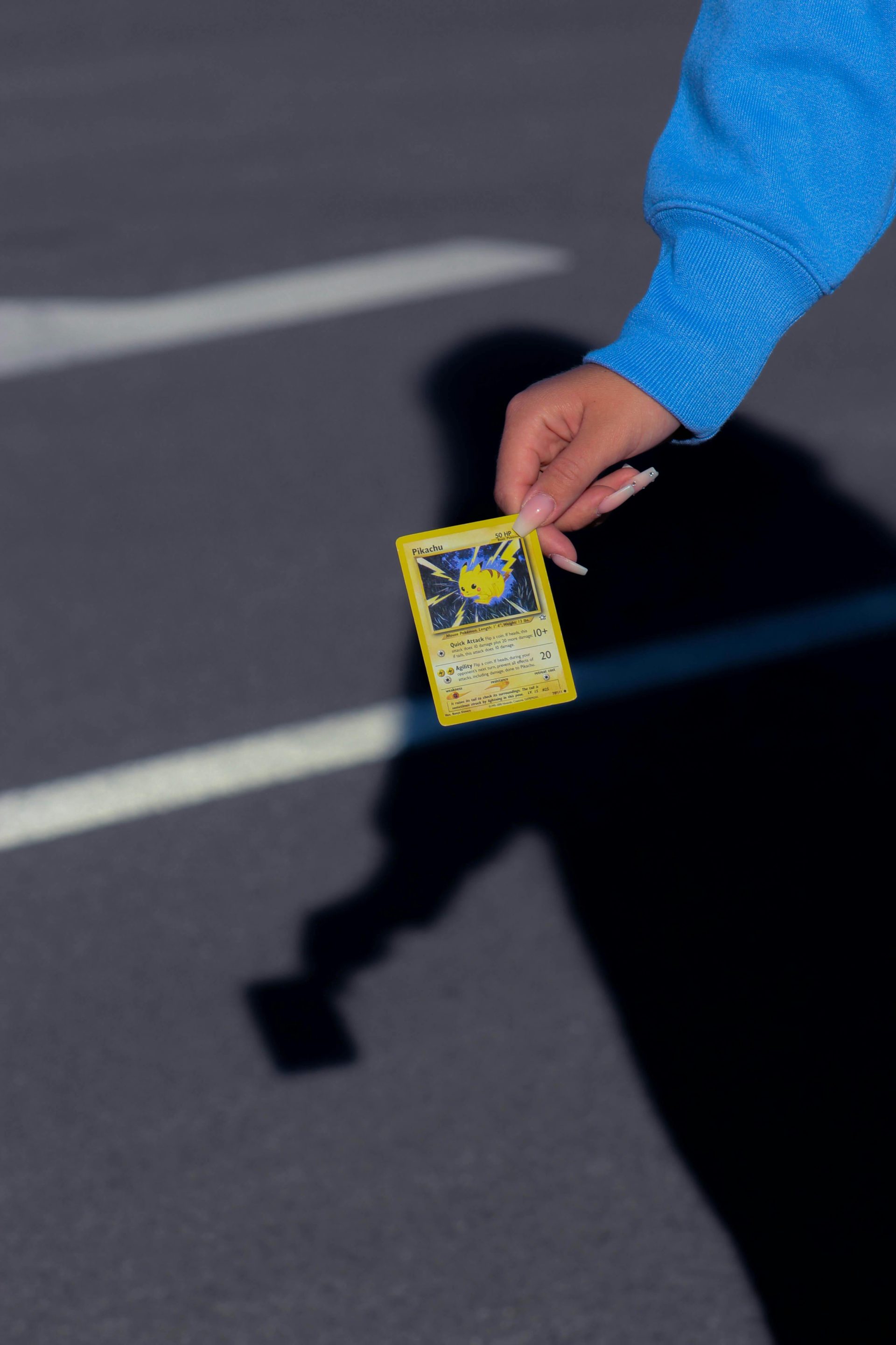 A hand holds collectible Charizard Pokemon cards with a blurred bokeh background. Perfect for trading card enthusiasts.