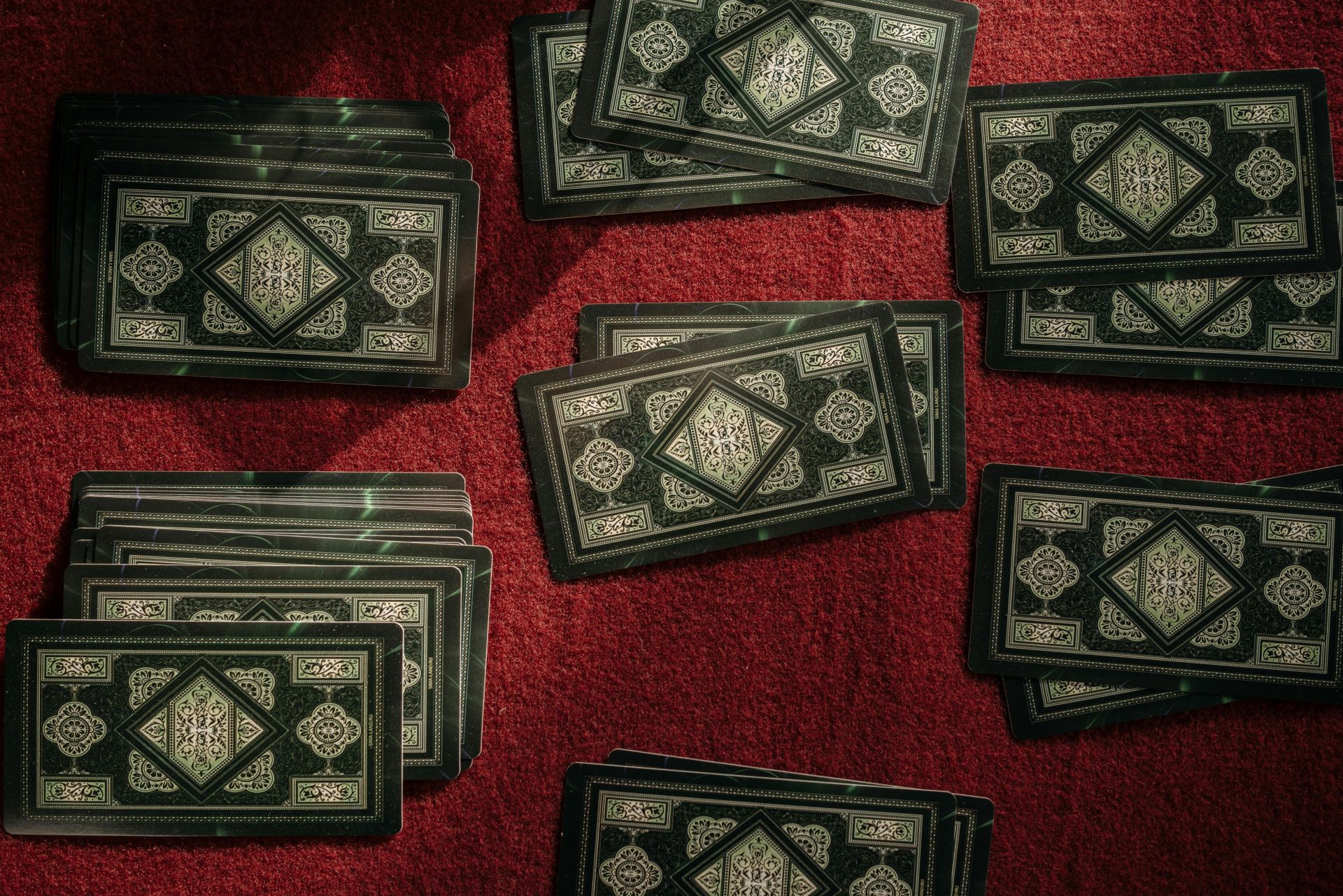 Top view of intricate playing cards on a rich red texture, perfect for game and mystery themes.
